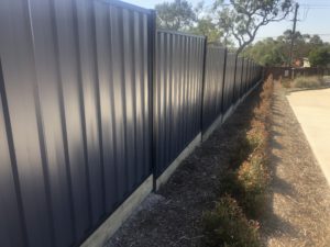 Stepped Colorbond fence with timber plinth