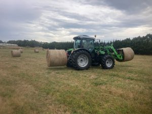 Collecting round hay bales.